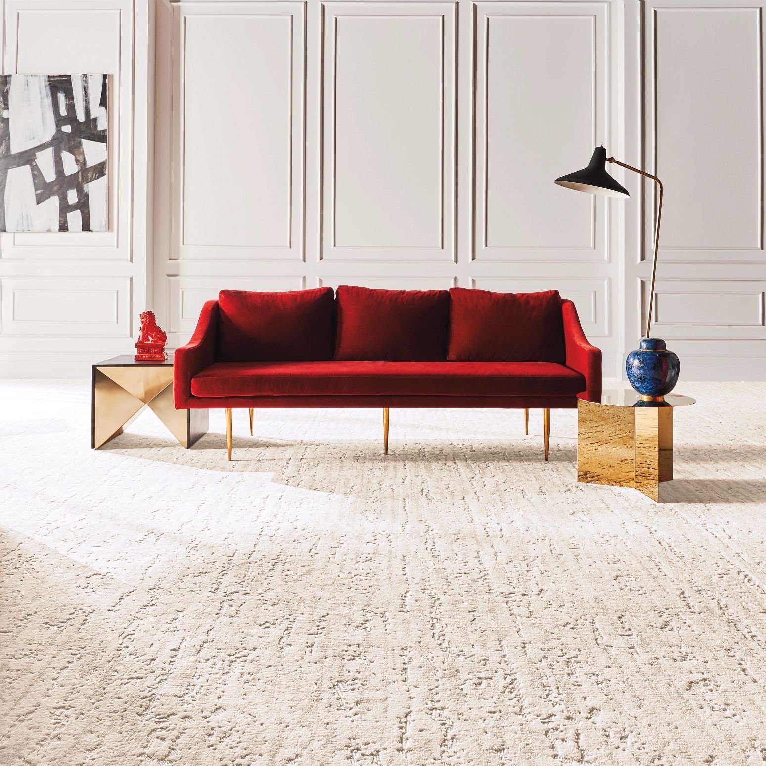 bright living room with a red velvet couch and cream colored textured carpet from Carpet Design Center in the Greenville, NC area